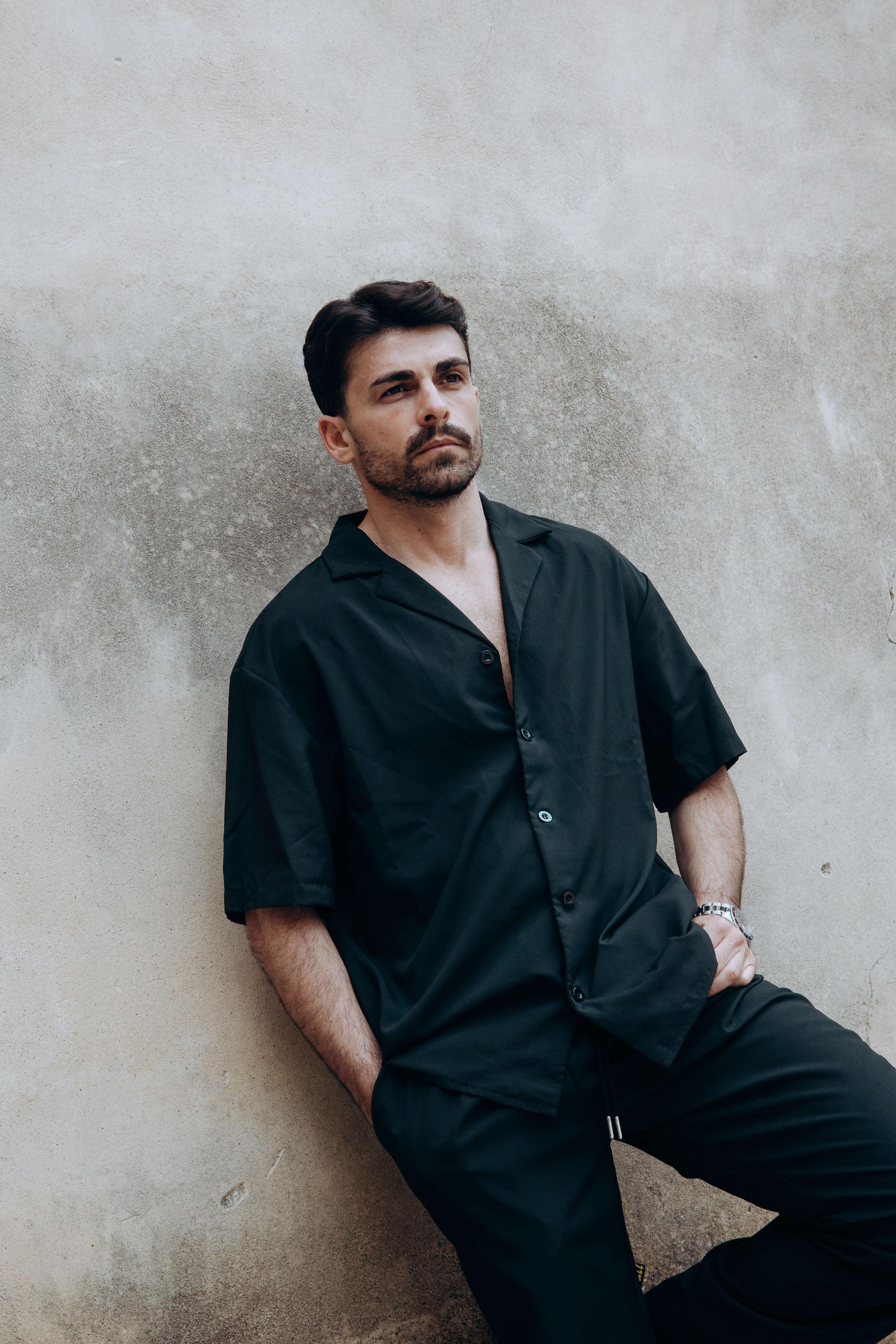 Ciuffo voluminoso pettinato indietro, sfumatura sui lati, barba corta con baffi — taglio realizzato da Antonio Nicosia a Valverde